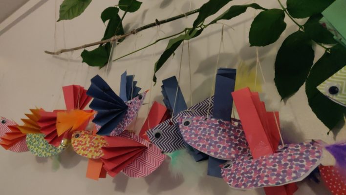 Oiseaux en papier plié, attachés à une branche, accrochée dans un hall d'entrée