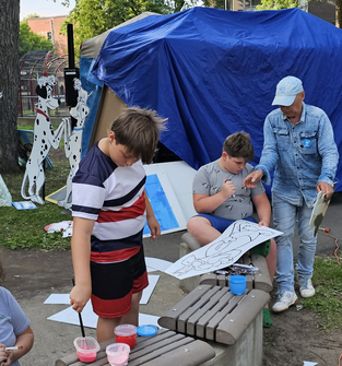 Des jeunes garçons qui peintures les décorations géantes